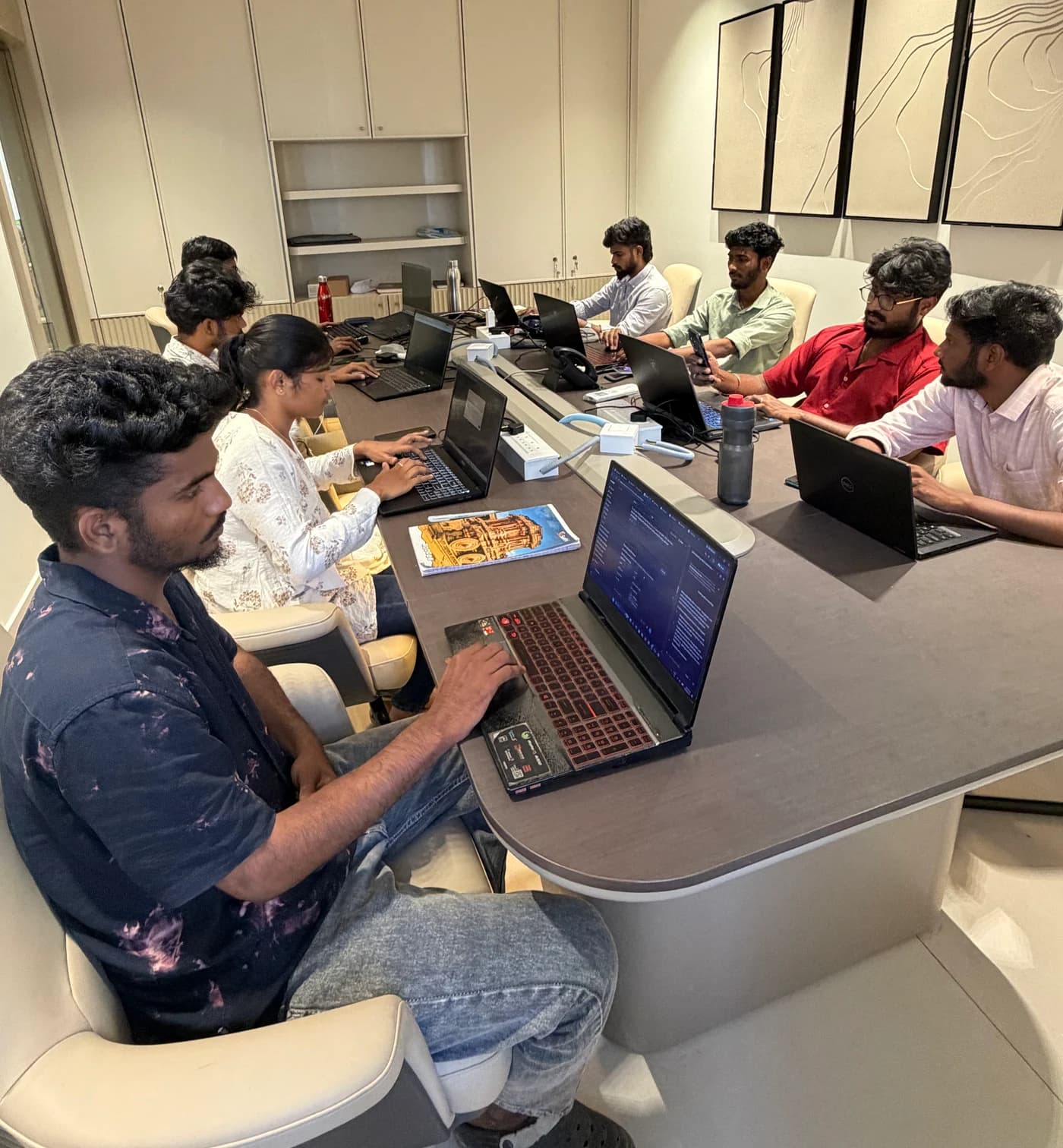 Tranz team members working together on laptops around the office table
