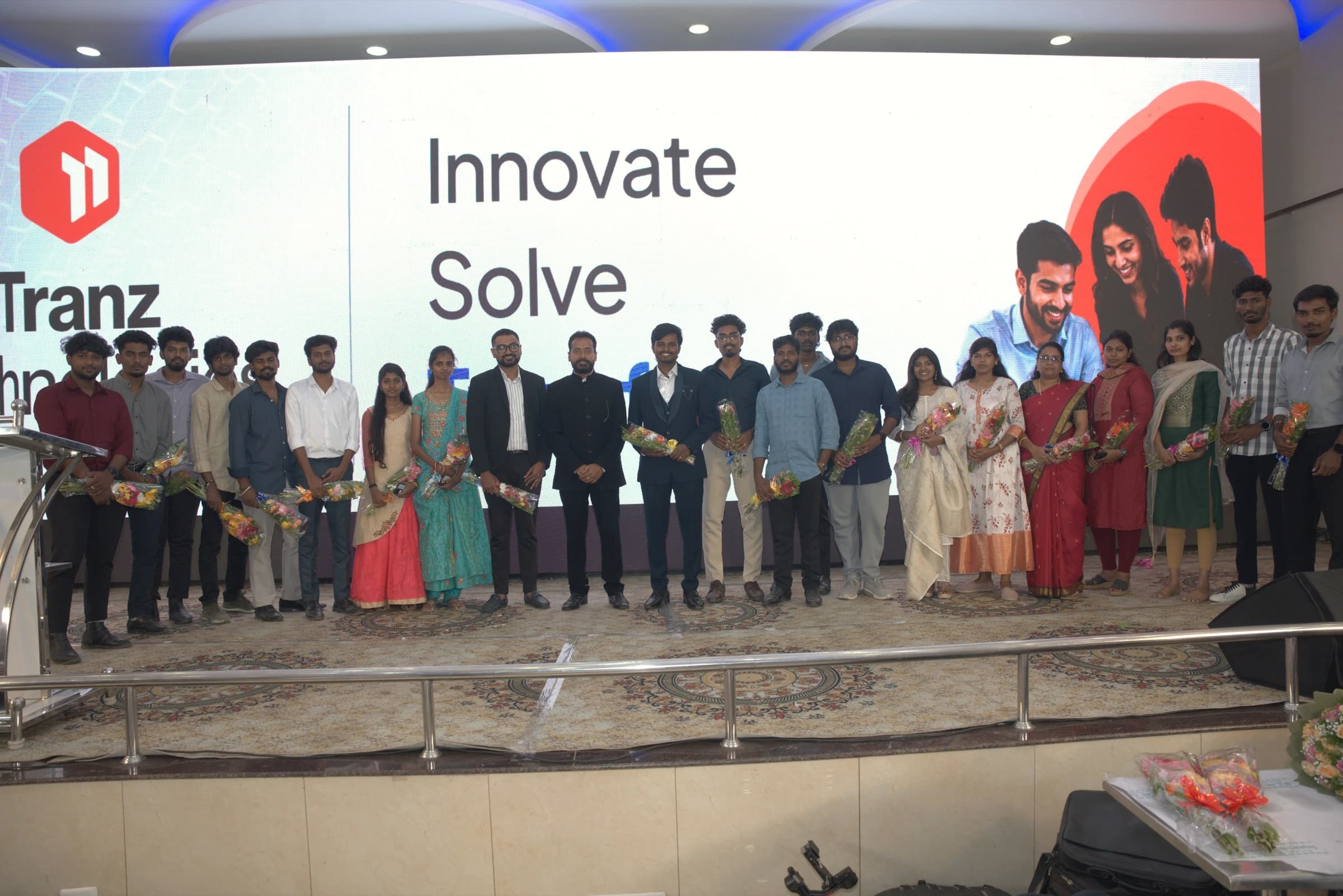 Tranz Technologies team standing together on stage holding bouquets