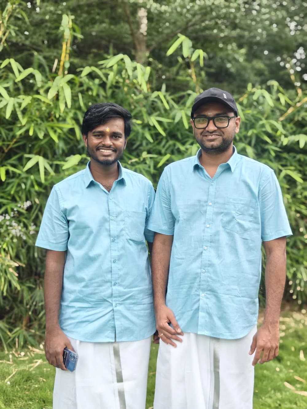 Two team members in matching blue shirts standing together outdoors